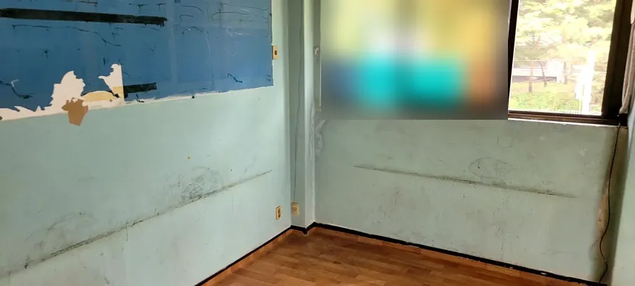 가구정리 후 가구가 모두 비워진 같은 학원 교실의 창가 벽면